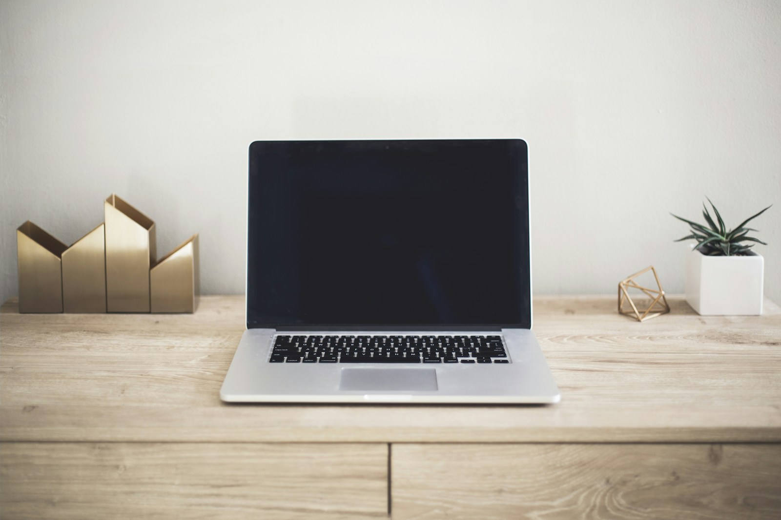 A focused workspace with a laptop and notebook